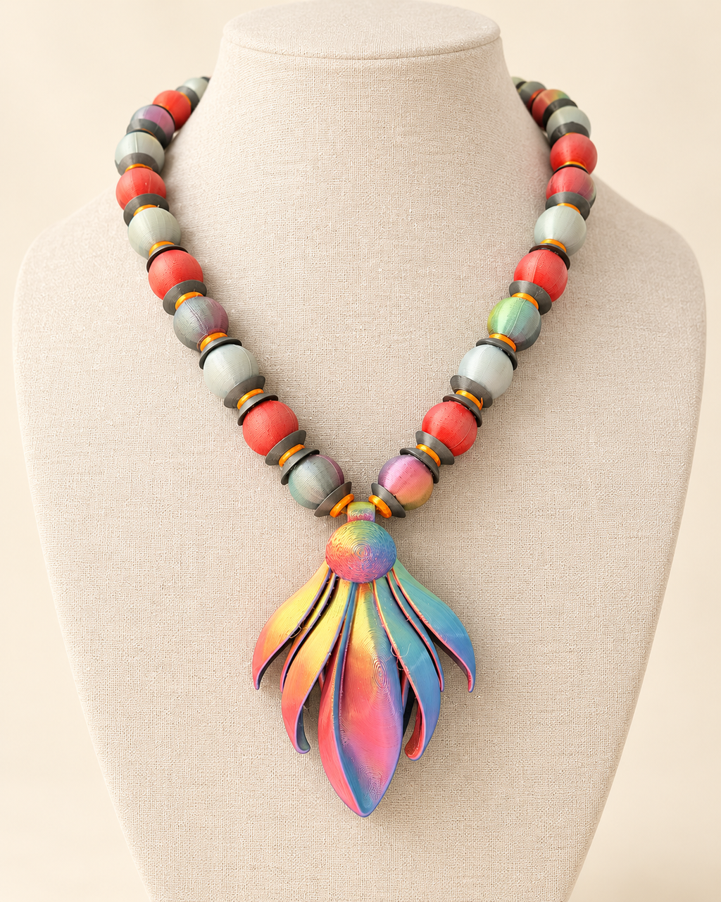 Candela Frailejón necklace by CATE, matte and iridescent PLA beads with an iridescent pendant, shown on a bust.