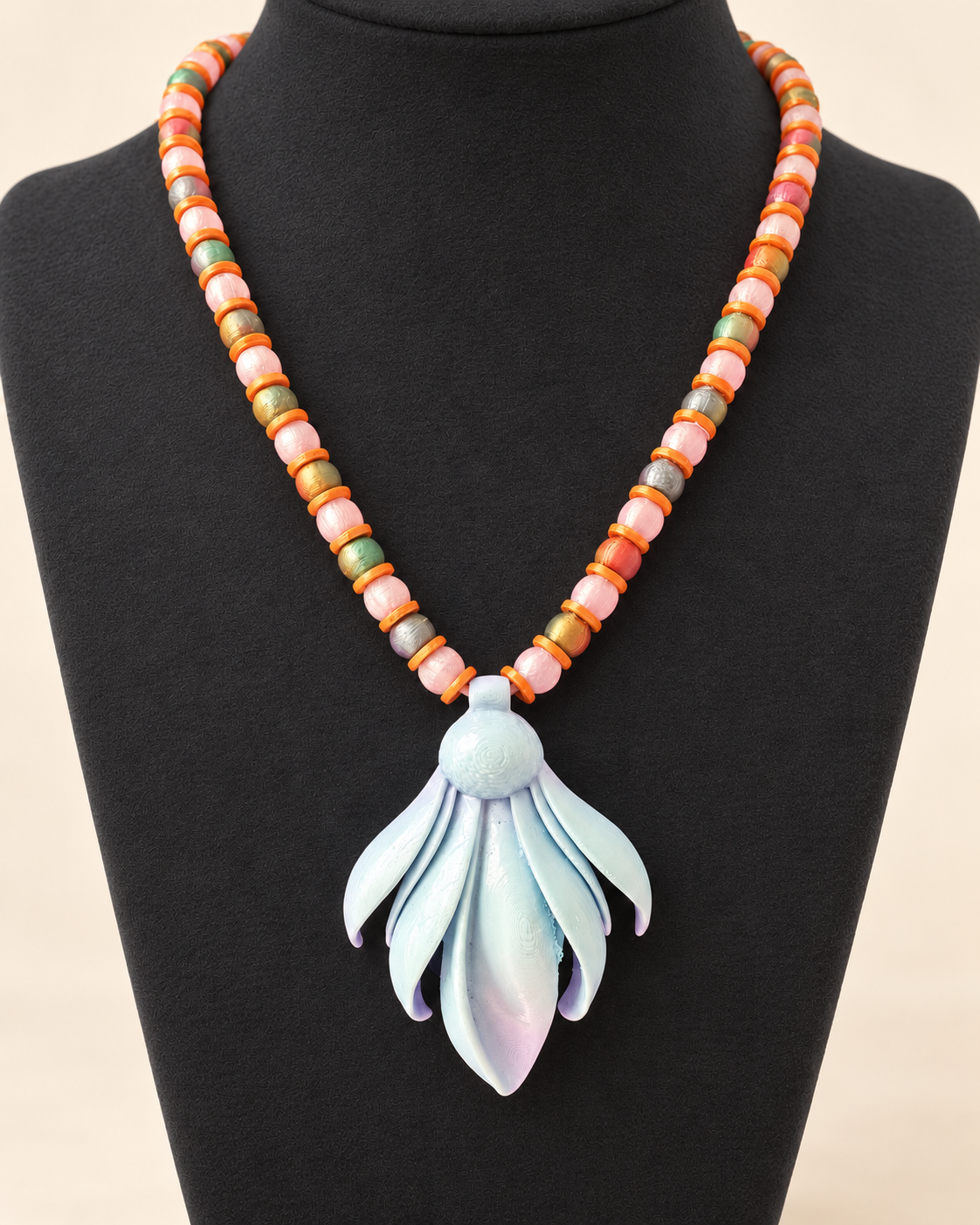 Rocío Frailejón necklace by CATE, pink clear and iridescent green beads with a UV resin finish pendant, shown on a bust.