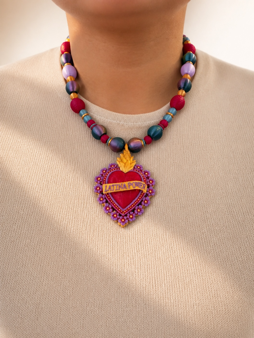 Woman wearing Latina Power sacred heart necklace, full pendant and beaded collar view in natural light