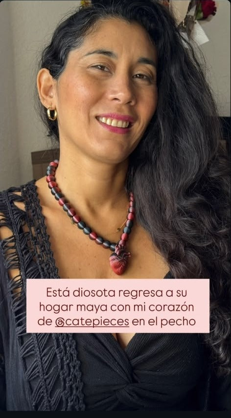 Mujer usando collar con dije de corazón CATE, con cita de testimonio